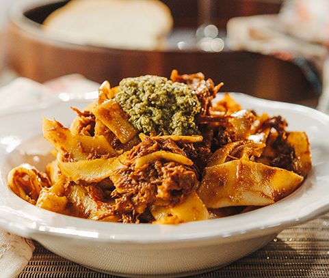 Bowl of pasta with beef ragu served with pesto